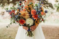 a woman holding a bouquet of flowers in her hands