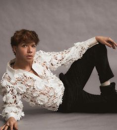 a woman in white shirt and black pants laying on the ground