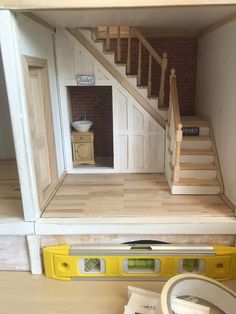 a doll house with stairs, sink and toilet in the room next to it's measuring tape