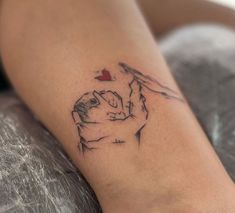 a woman's leg with a tattoo on it that has a horse holding a heart