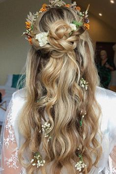 the back of a woman's head with long hair and flowers in her hair