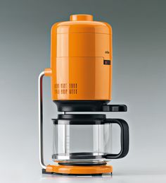 an orange coffee maker sitting on top of a table