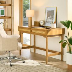 a desk with a chair, lamp and pictures on the shelves in front of it