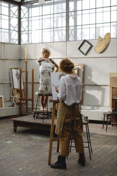 two women are standing in an art studio