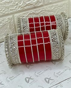 two red and white bangles on top of a box with silver trimmings