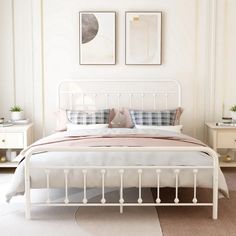 a white bed sitting in a bedroom next to two framed pictures