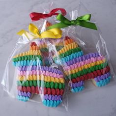 some cookies in the shape of a rainbow horse are wrapped in cellophane and tied with ribbon