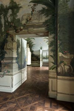 an ornate hallway with paintings on the walls and flooring is pictured in this image