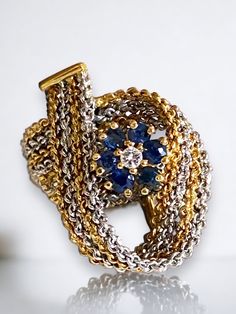 GORGEOUS Estate 18k Two Tone Gold Chain Link Diamond and Sapphire BOLD Statement Ring * Crafted of solid 18k gold, this unique and beautifully designed ring is sure to become a family treasure! * Flower crafted from six (6) genuine sapphires with a diamond center, sits nestled in this unique two tone gold chain design setting! * Size 5.75 * Weight: 9.1 grams of solid 18k (750) Shipped FAST AND FREE, in original gift box, fully insured :) I guarantee item to be exactly as described and pictured. Unique Gold Sapphire Ring Hallmarked, Luxury Multi-strand Necklaces With Complimentary Chain, Luxury Multi-strand Chain Jewelry, Luxury Yellow Gold Multi-strand Jewelry, Luxury 14k Gold Tarnish-resistant Chain Ring, Luxury Gold-tone Statement Chain Necklace, Gold Chain Design, Chain Design, Ring Crafts