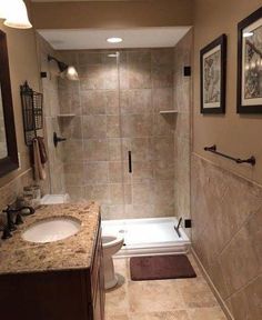 a bathroom with a walk in shower next to a white toilet and bathtub under two framed pictures on the wall