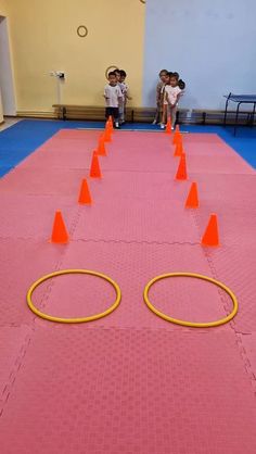 two children are playing with orange cones on the floor