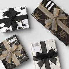 three wrapped presents with black and gold bows