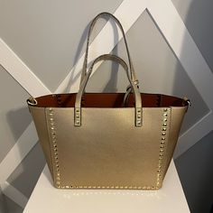 Brand New, Trendy Studded Tote. It’s Soft Vegan Leather And It’s Super Cute! It Comes With A Pouch, And Strap. It Will Be Coming From A Pet/Smoke Free Home. Gold Shoulder Bag With Branded Hardware And Double Handle, Gold Tote Shoulder Bag With Top Carry Handle, Gold Leather Bags With Branded Hardware, Gold Bags With Branded Hardware And Double Handle, Gold Shoulder Bag For Shopping, Gold Tote Bag For Shopping, Gold Shoulder Bag With Branded Hardware, Gold Tote Shoulder Bag For Errands, Gold Leather Shopping Bag