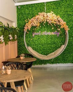 the inside of a restaurant with tables, chairs and a green wall behind it that says happy mother's day