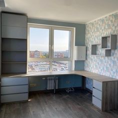 an empty kitchen with blue and white tiles on the walls, cabinets and drawers in front of a large window