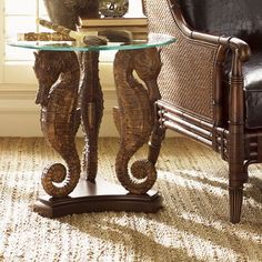 an elephant statue sitting on top of a glass table next to a black leather chair