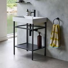 a white sink sitting under a mirror next to a wall mounted soap dispenser