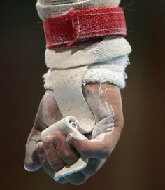 a close up of a person's hand with white gloves and red wristbands