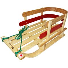 a wooden sled with red and green straps