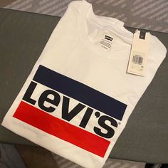 Never Worn Levi’s T-Shirt. Levi's White Short Sleeve Shirt, Casual White Logo T-shirt, Levi's White Cotton Top, Levi's White Relaxed Fit Shirt, Tan Graphic Tee Shirt With Logo Print, Tan Graphic Tee With Logo Print, Casual White Levi's Top, Cotton Crew Neck Shirt With Logo, White Cotton Levi's Top