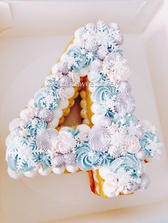 a letter made out of frosted cookies in a box