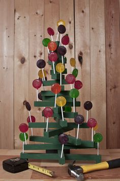 a christmas tree made out of pops and lollipops on a wooden table