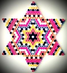 a star made out of circles and dots on a white background with black, yellow, pink, and orange colors