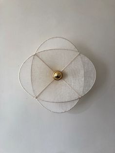 an object that is on top of a white surface with a gold ball in the middle