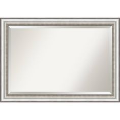 a silver framed mirror on a white wall