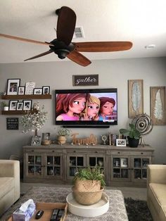 a living room with a large television mounted to the wall and pictures on the wall