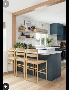 a kitchen with blue cabinets and white counter tops, wooden flooring and open shelving