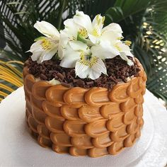 a close up of a cake with white flowers on the top and brown icing