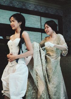 two women in dresses are standing next to each other