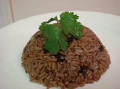 a white plate topped with rice and garnished with cilantro leaf sprigs