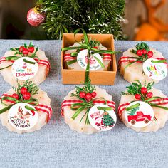 six soaps wrapped in red and green ribbon sitting on a table next to a christmas tree