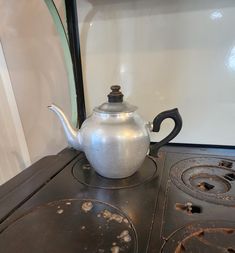 a tea pot sitting on top of an old stove