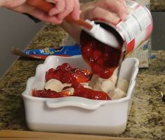 someone is adding jelly to ice cream in a white bowl on a counter top with other ingredients