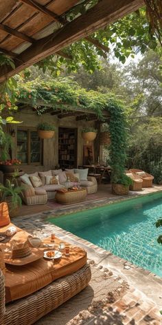 an outdoor living area next to a swimming pool with wicker furniture on the patio