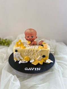 a cake with a baby on top that says half way to one gavin '