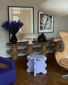 a living room filled with furniture and pictures on the wall next to a table topped with flowers