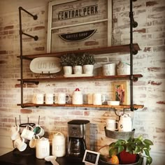 a coffee bar with cups and mugs on the shelves above it, along with other items