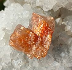 two pieces of orange colored rock sitting on top of some white rocks