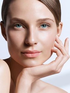 a beautiful woman with blue eyes posing for the camera and holding her hand near her face