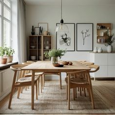 a dining room table with chairs and pictures on the wall in front of it's windows