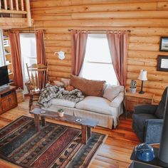 a living room filled with furniture and a flat screen tv on top of a wooden wall