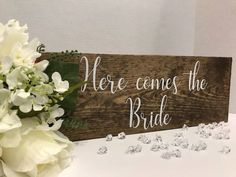 there is a wooden sign that says, here comes the bride with diamonds on it