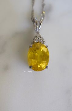 Metal: 14kt White Gold Stone: Yellow Sapphire And Diamond Stone Shapes: Round And Oval-Shape Yellow Sapphire Weight: 3.27 ctw, 9.84 x 7.82 mm Diamond Weight: .08 ctw, round diamonds Measurements Of Pendant From Bail To Bottom Of Pendant: 19.93 mm Weight of entire piece with chain: 2.50 grams Type of Chain: 1.2mm Diamond-cut Singapore Chain Length of Chain: 16 Inches Type of Lock: Spring Ring Note: Other chain styles and lengths available. Pendant can also be sold without chain. Please inquire if Exquisite Oval Brilliant Cut Gemstones, Exquisite Oval Brilliant-cut Gemstones, Oval Brilliant Cut Gemstones For Fine Jewelry, Gia Certified Oval Gemstones For Fine Jewelry, Elegant Oval Gia Certified Gemstones, Formal Oval Diamond-cut Gemstones, Gold Oval Gemstones With Brilliant Cut, Oval Diamond-cut Gemstones For Formal Occasions, Luxury Oval Diamond Cut Gemstones