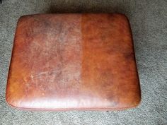 a brown leather cushion sitting on the floor