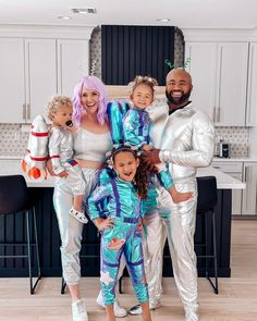 the family is posing for a photo in their silver pajamas and matching white outfits with blue hair