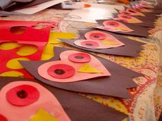 the table is covered in paper and decorated with pink, yellow, and red shapes